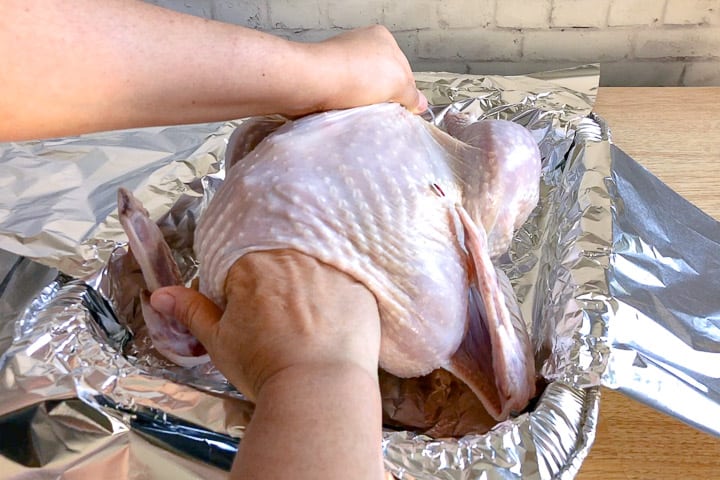 image showing the best way to cook a turkey by adding stuffing into the cavity by hand