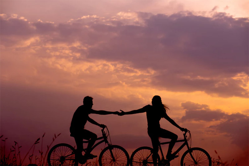 Silhouette of couple riding on bicycles