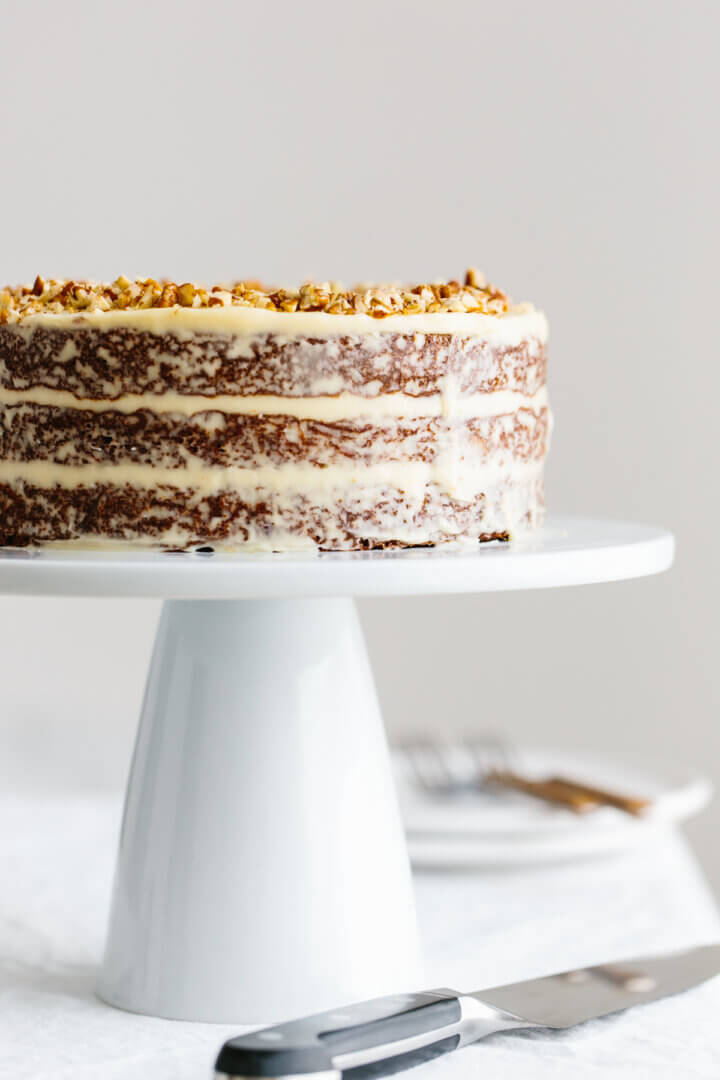Triple layer gluten-free carrot cake on a cake stand.