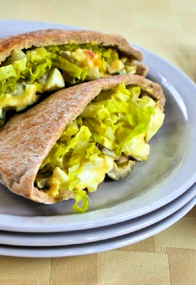 Egg Salad in Pita with Green Olives and Dijon finished pita filled with egg salad on plate