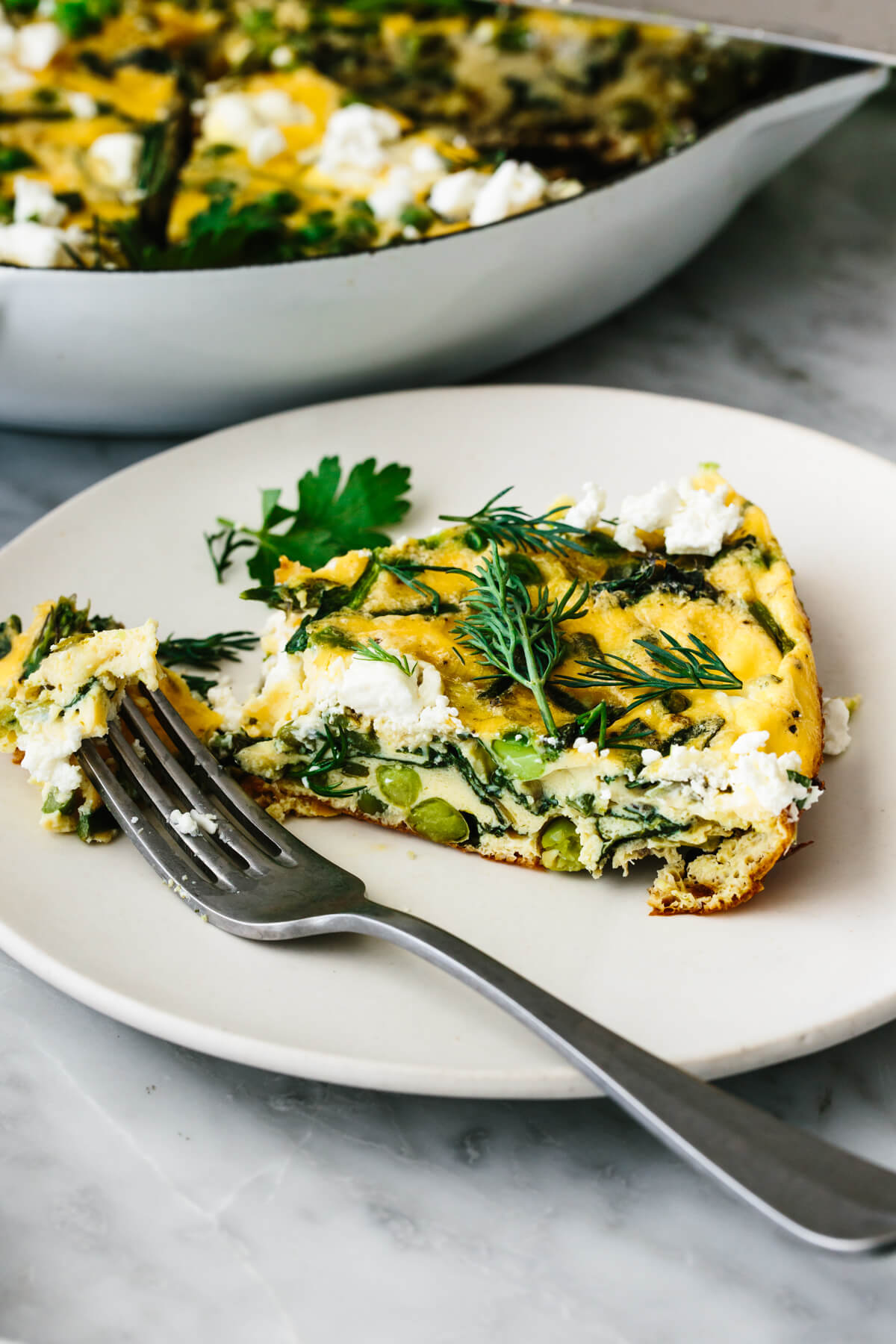 A slice of spring vegetable frittata on a plate