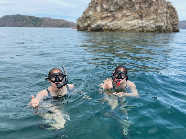 Two girls snorkeling in the ocean. 