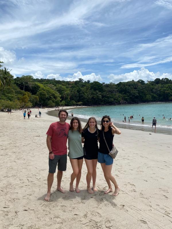 Family photo of four posing at the beach in Costa Rica. 