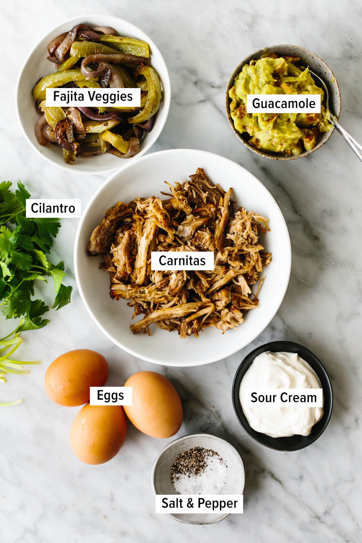 Ingredients for a carnitas omelette on a table.