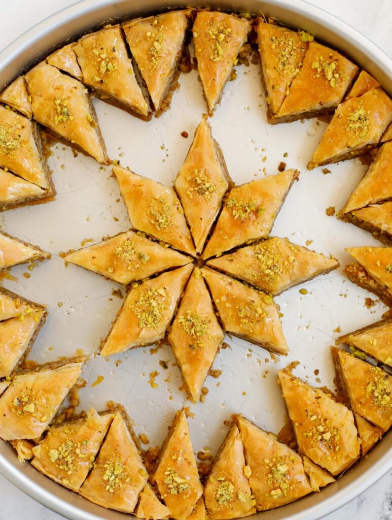 Walnut baklava in a pan with pieces removed.