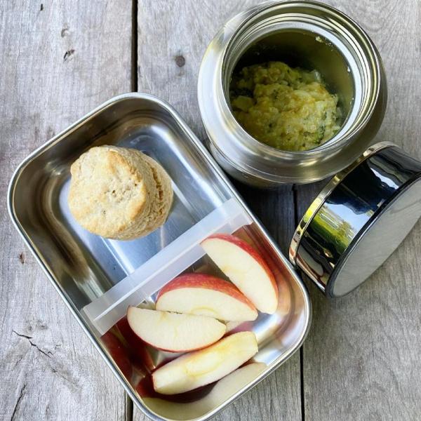 Packed school lunch that includes leftover Chicken and Broccoli Curry Casserole in a thermos, homemade biscuit and some apple slices. 
