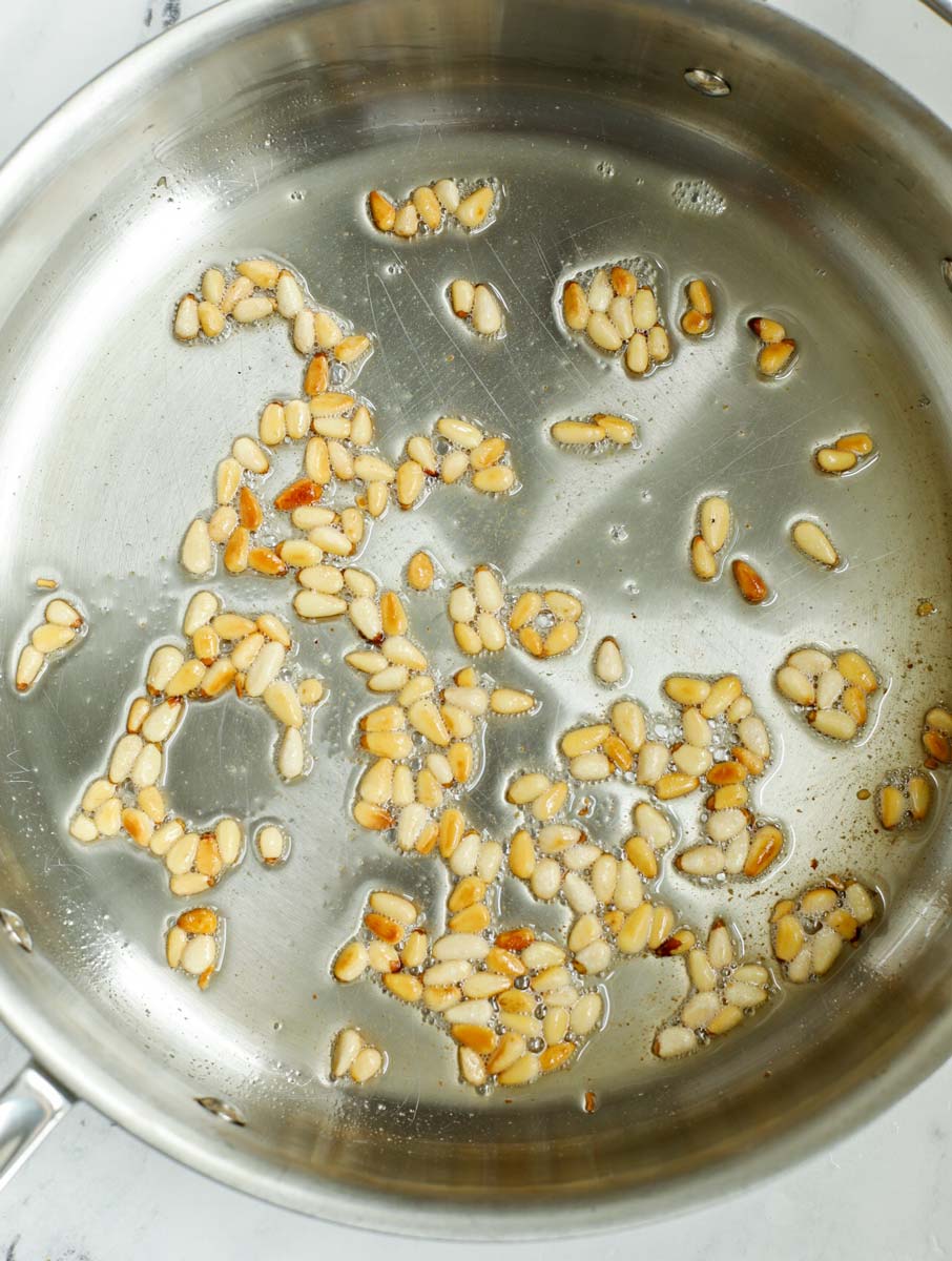 pine nuts being fried in a pan.