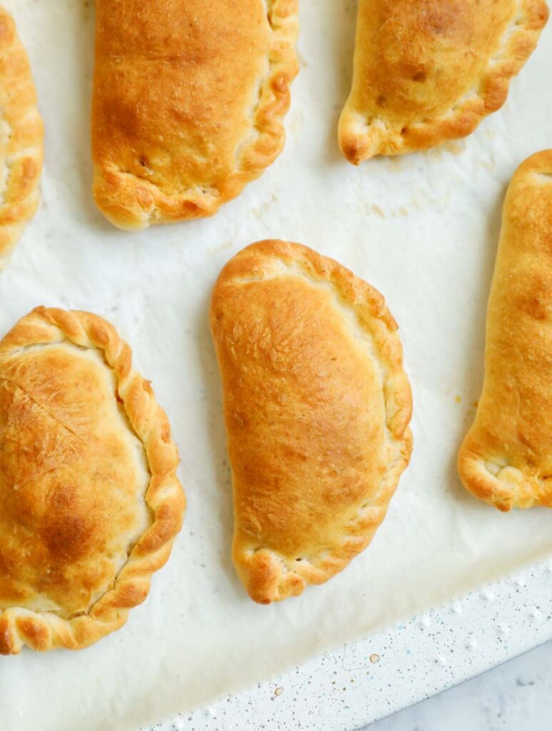 Baked meat pies on a parchment sheet.