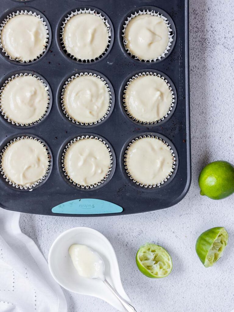 cheesecake filling in a muffin tin pan lined with cupcake holders