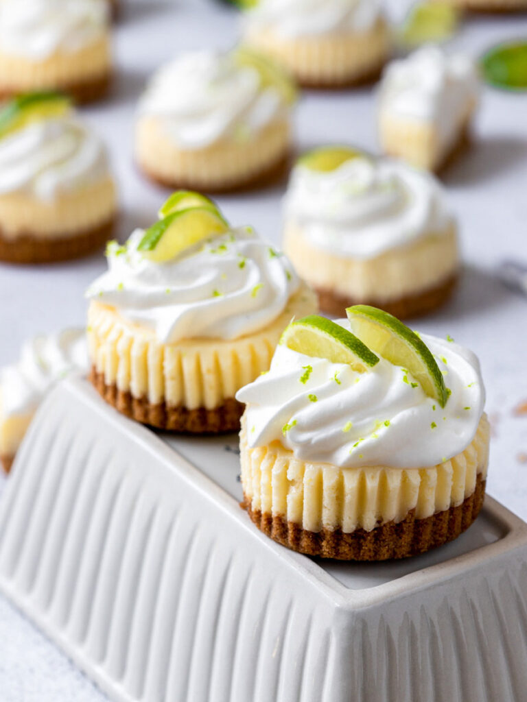 mini keylime cheesecake topped with whipped cream and lime slices