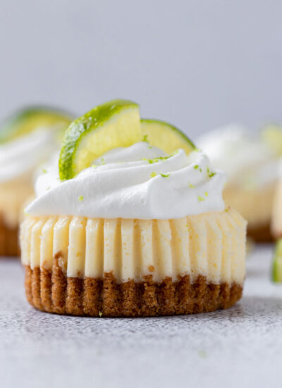 close up shot of mini key lime cupcake with whipped cream and lemon slices on top