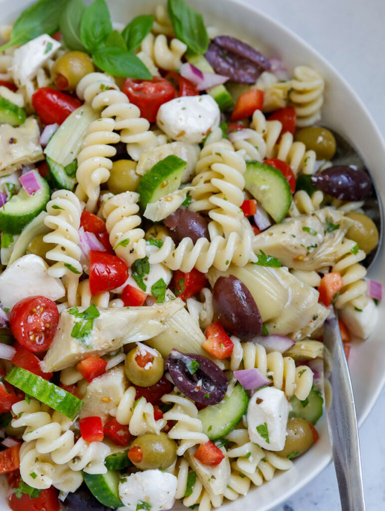 Close up of a bowl of Mediterranean pasta salad.