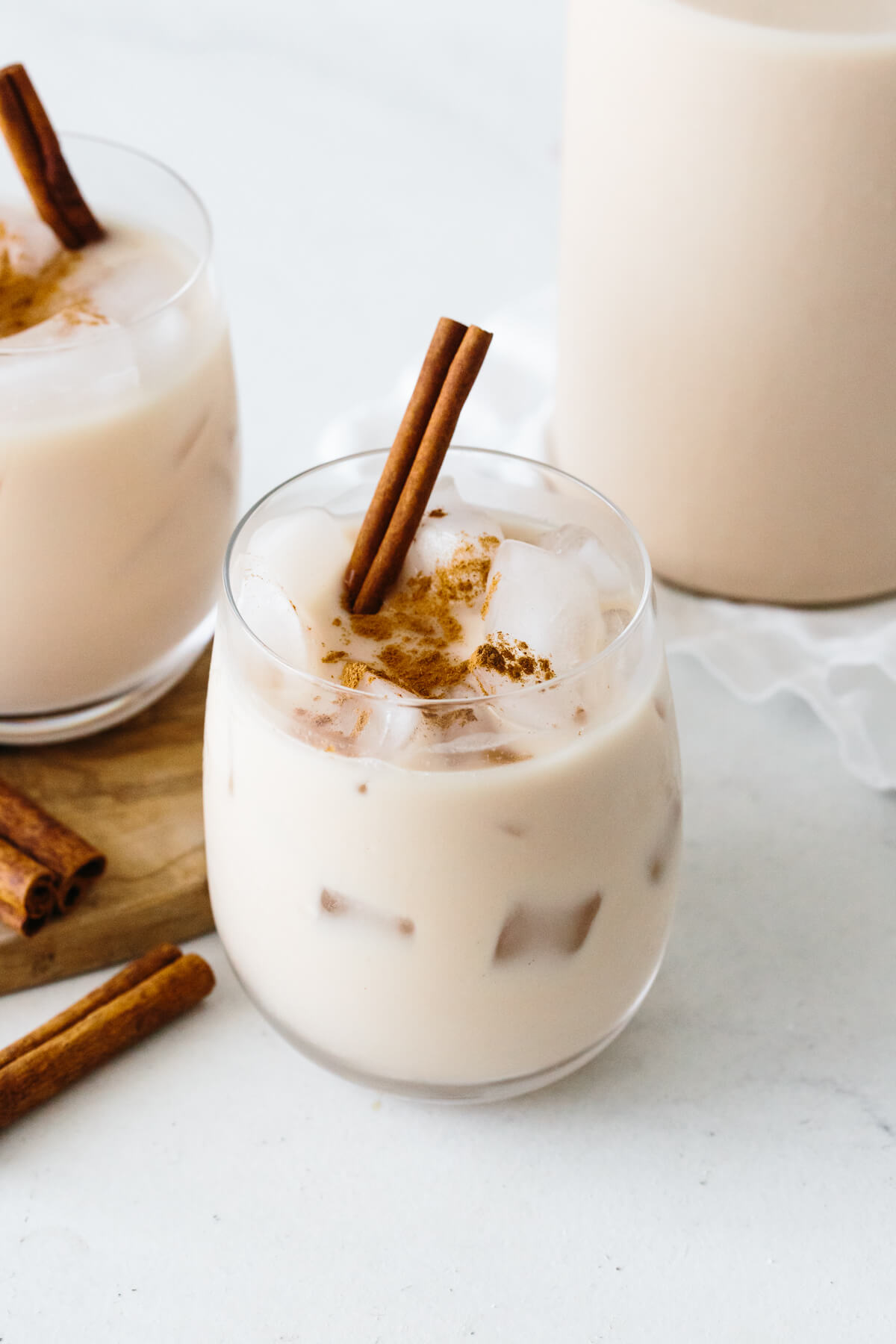 Horchata in a glass with cinnamon stick.