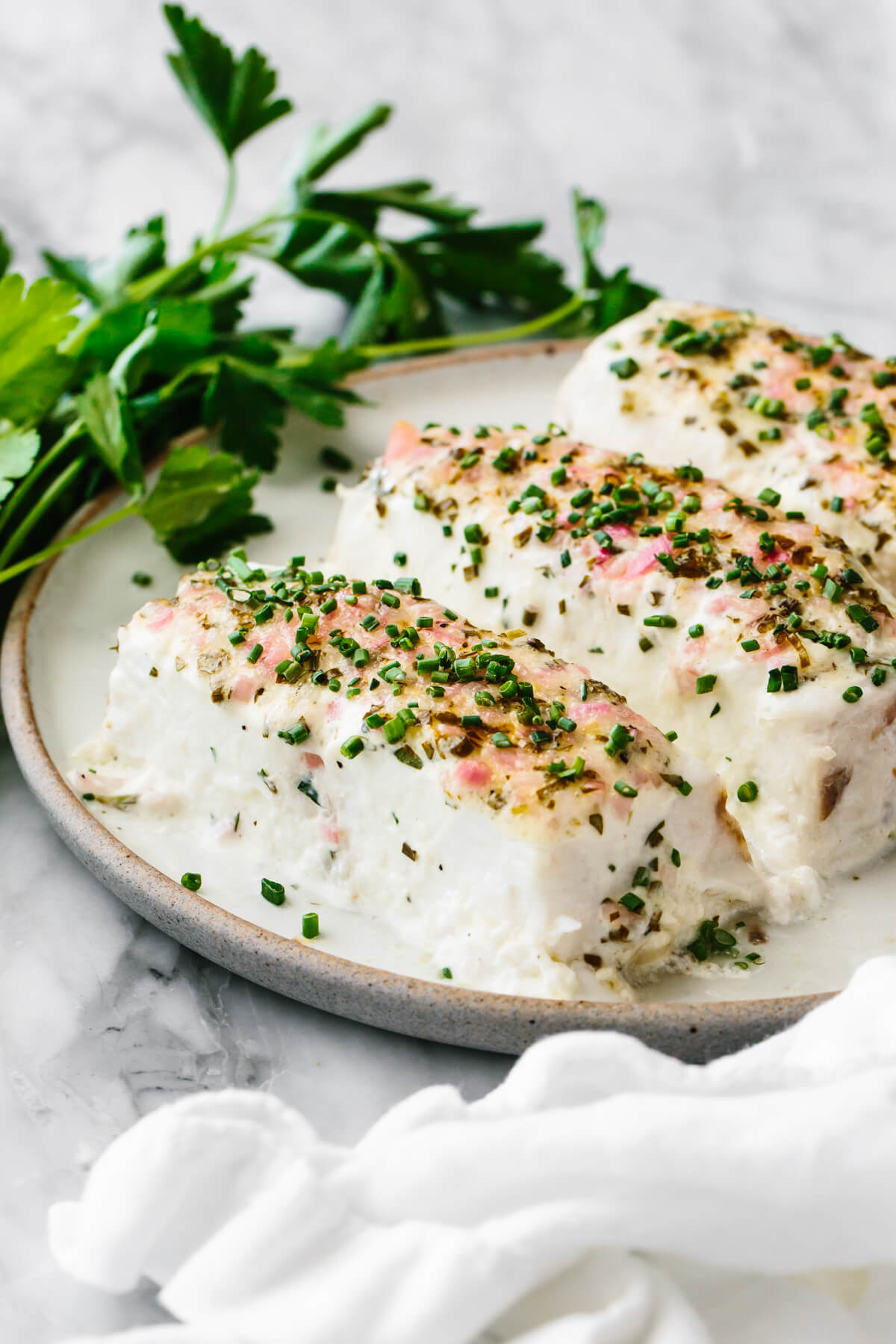 Baked halibut with herbed mayonnaise crust on a plate.