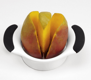 A mango being sliced with a cutting tool. 