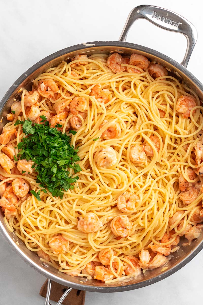 garlic shrimp spaghetti in a pan topped with parsley