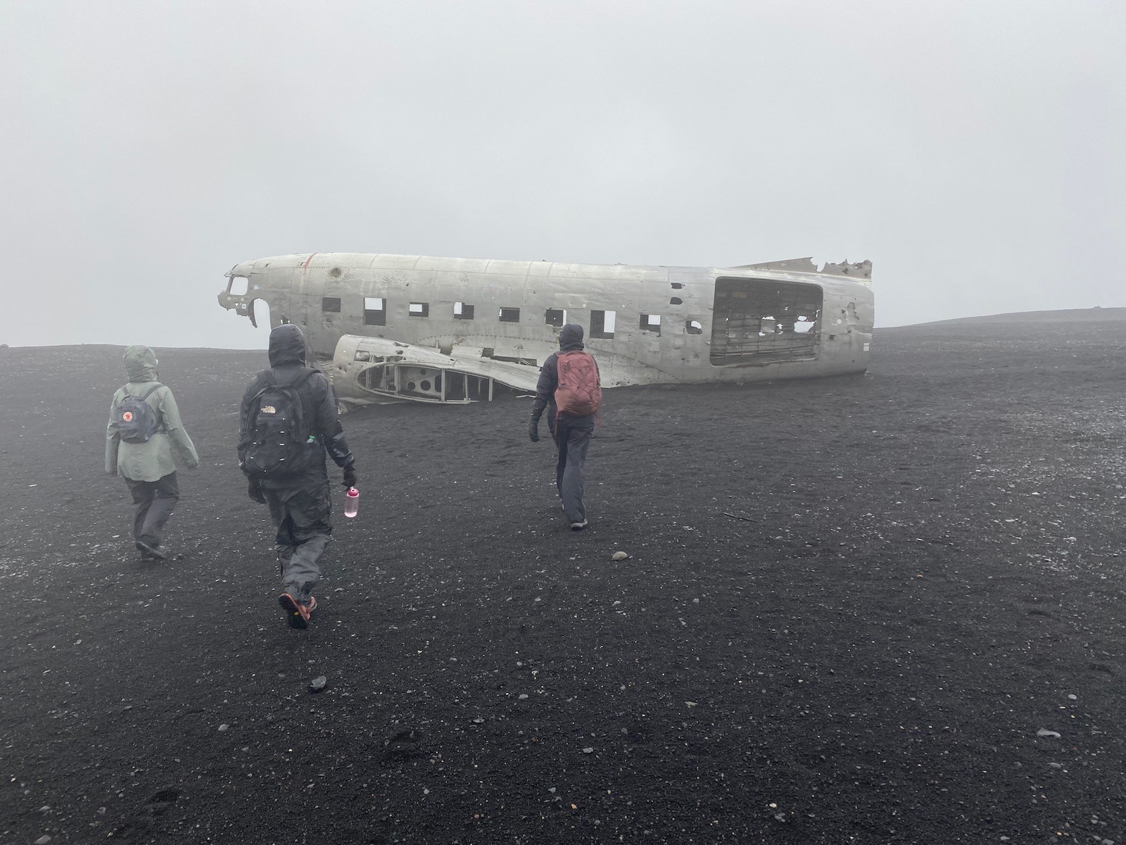 Family walking towards the famed 1973 plane wreck in Iceland. 