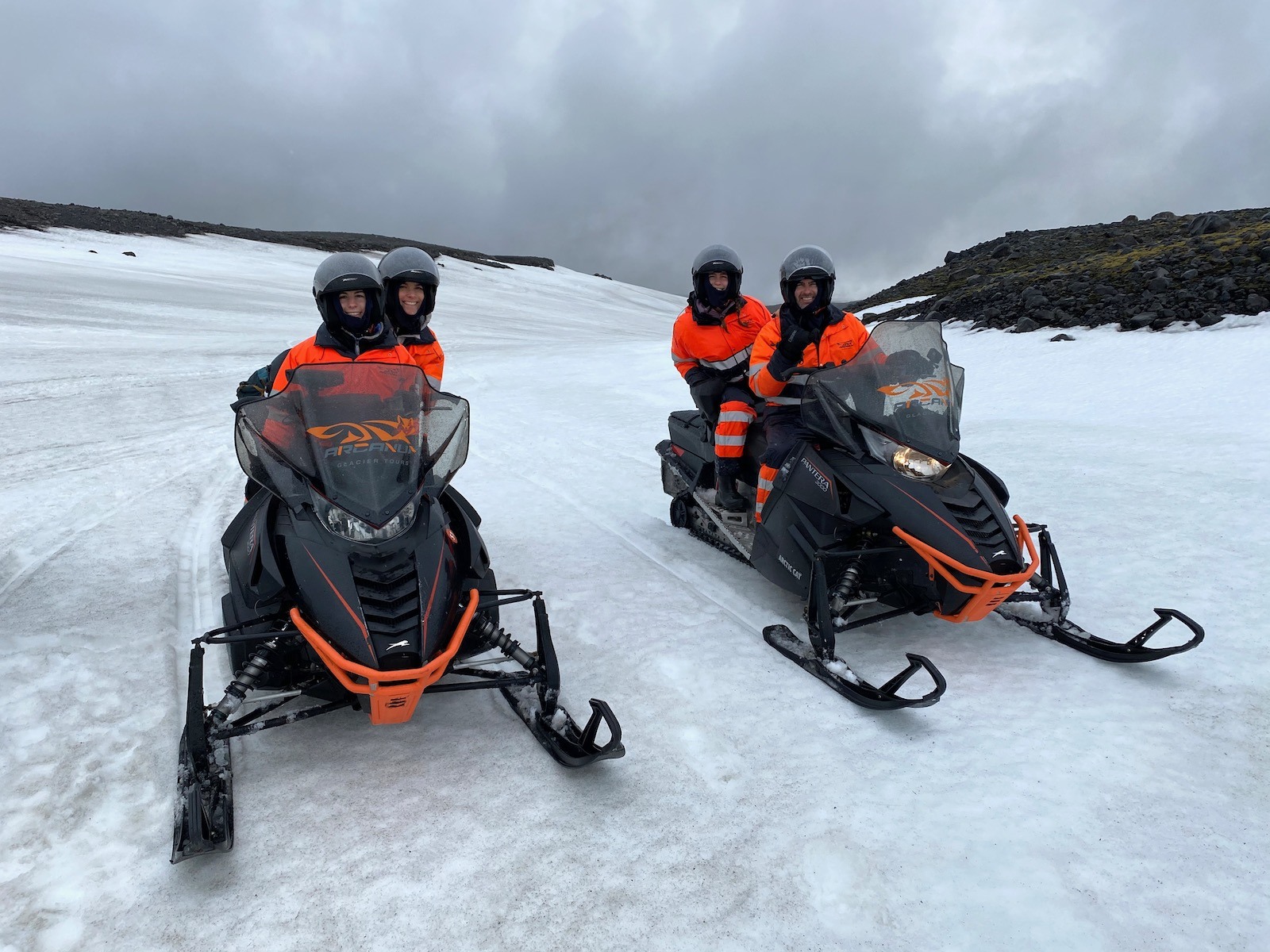Family posing on snowmobiles in Iceland. 