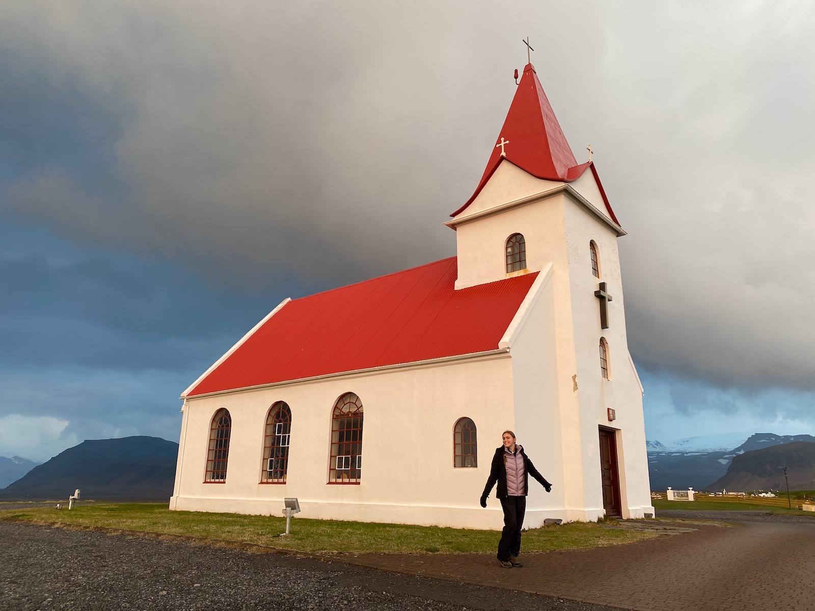 Teen girl posing in front of a quaint little church in Iceland. 