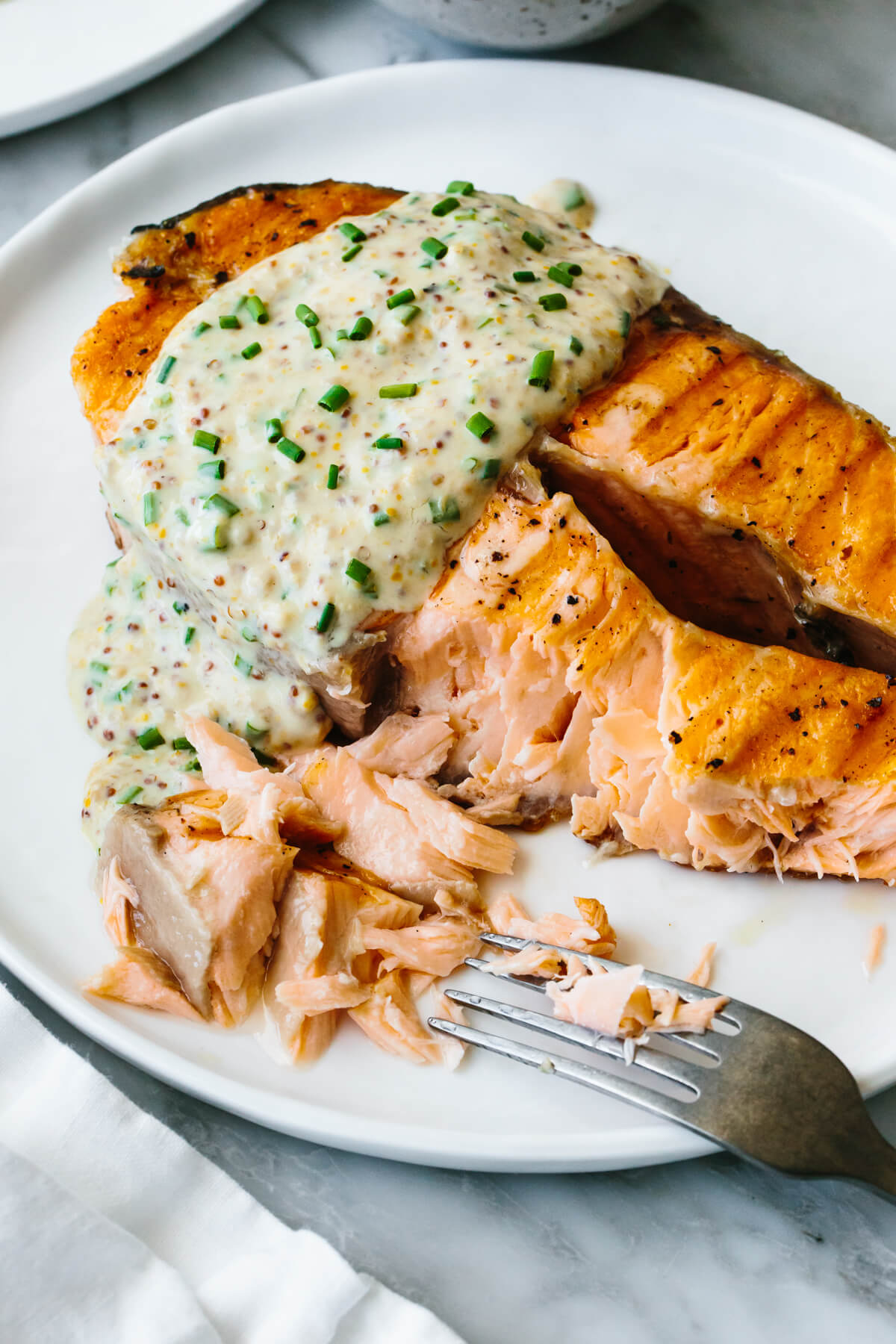 Grilled salmon steak on a plate with a fork