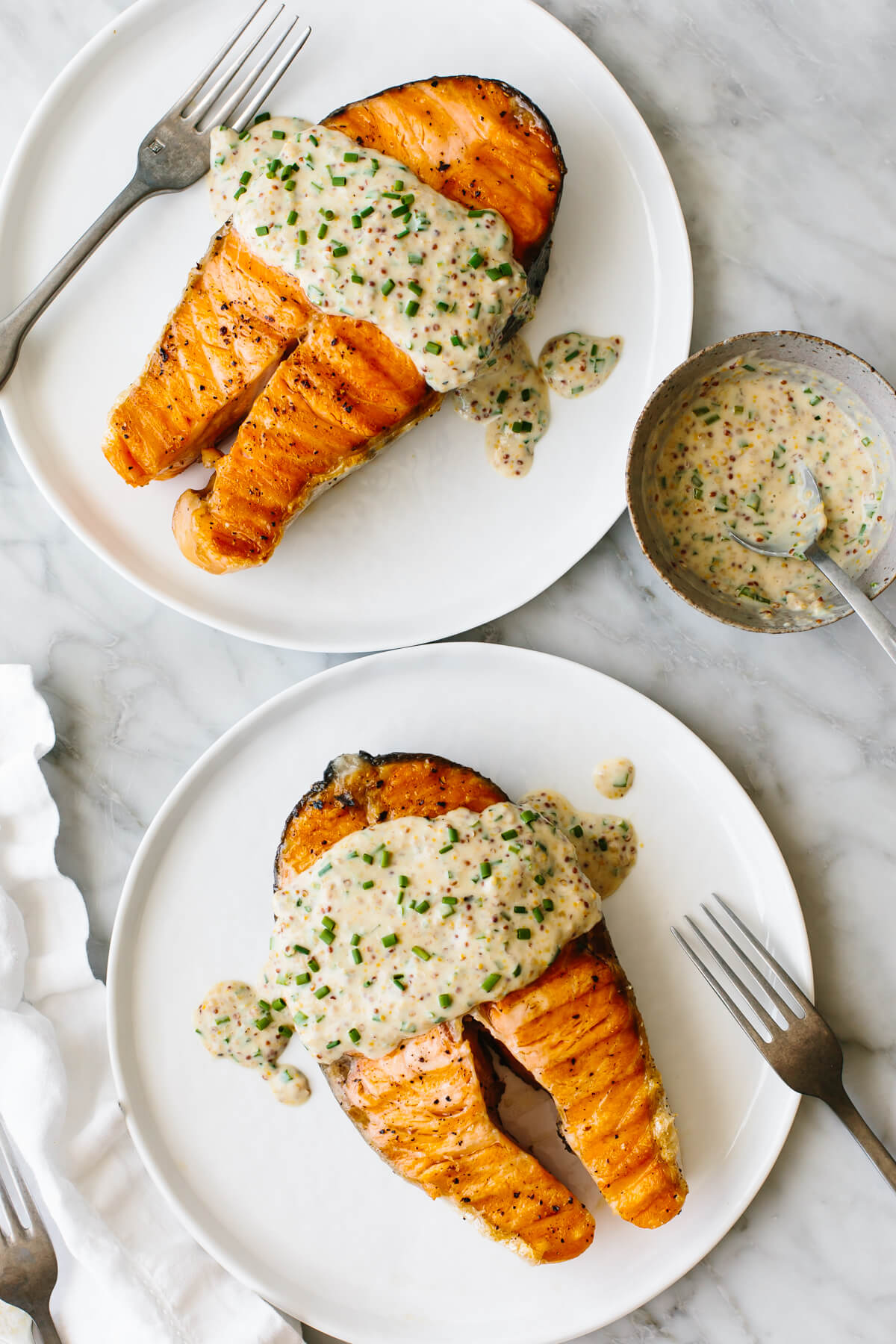 Grilled salmon steaks on two white plates