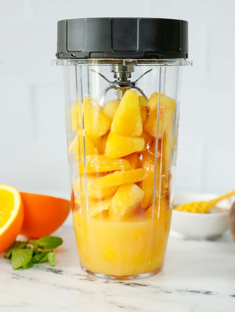 Peach N' Orange slushie ingredients inside of a blender.