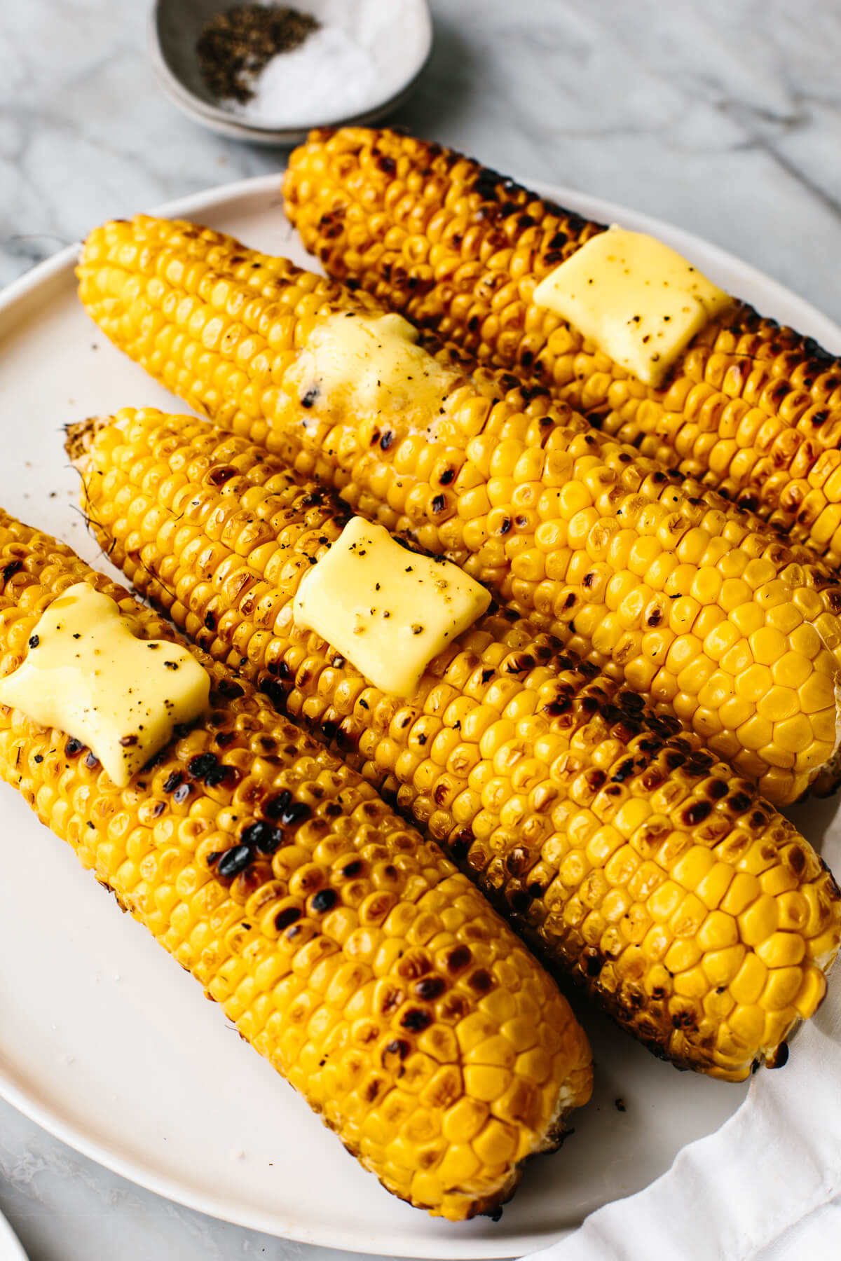 Grilled corn on the cobs withe butter on a plate