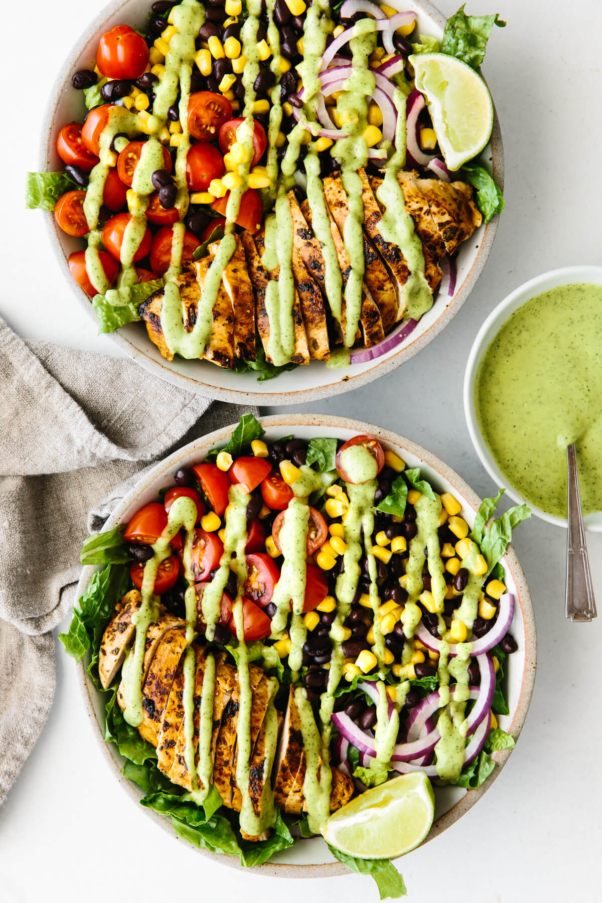 Two southwest chicken salads drizzled with avocado dressing.