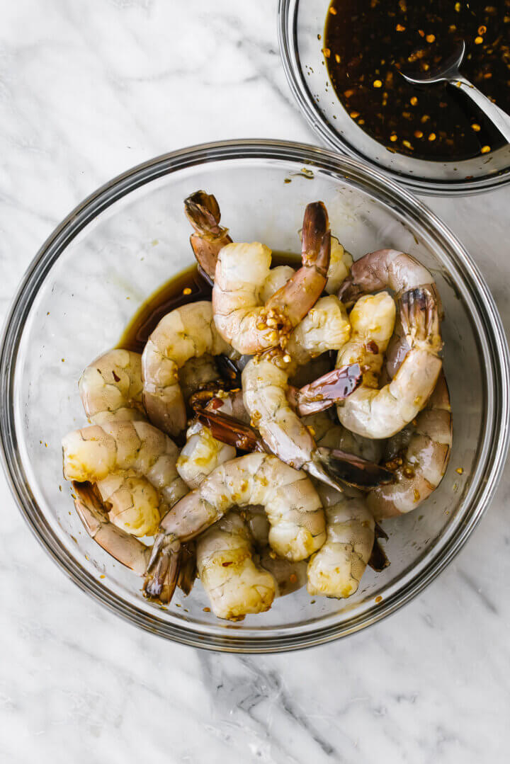 Marinating honey garlic shrimp in a glass bowl.