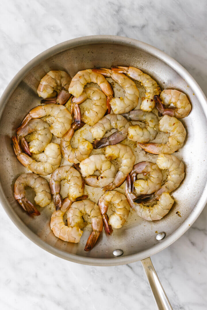 Cooking shrimp in a pan for honey garlic shrimp