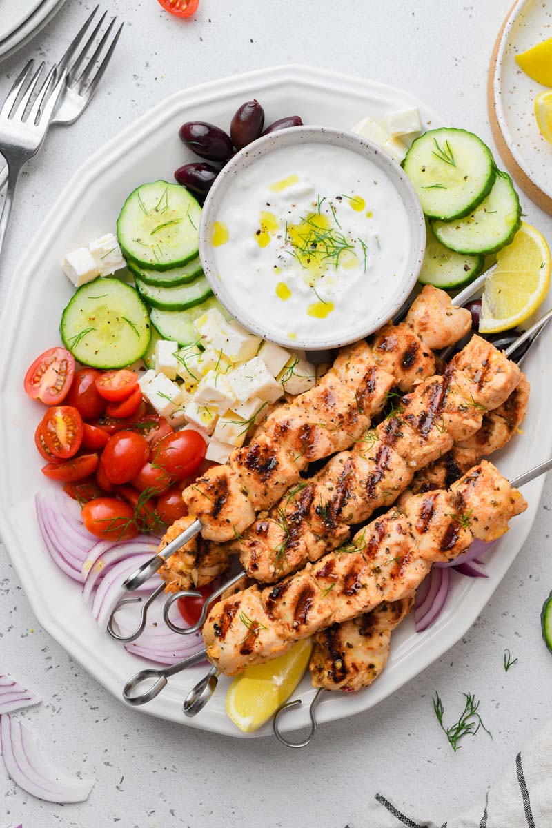 top down shot of the greek chicken skewer dish served with sides
