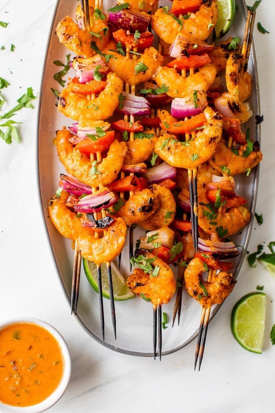 Shrimp Skewers with onions, bell pepper and lime wedges