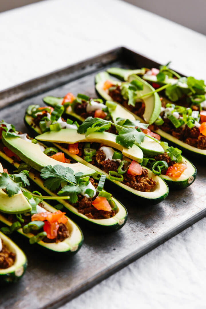Stuffed zucchini boats with ground beef and taco toppings.