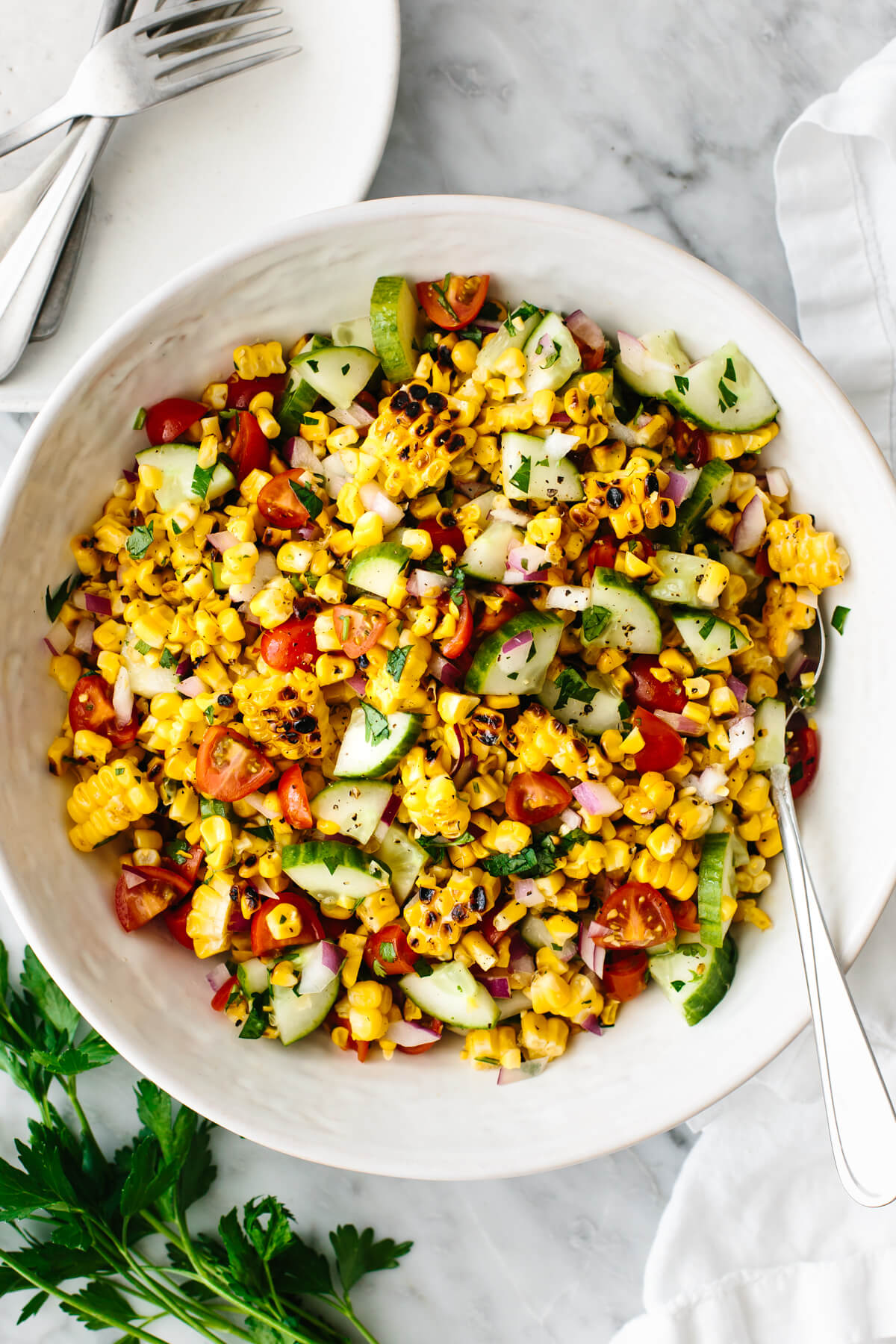 Grilled corn salad in a large white bowl.