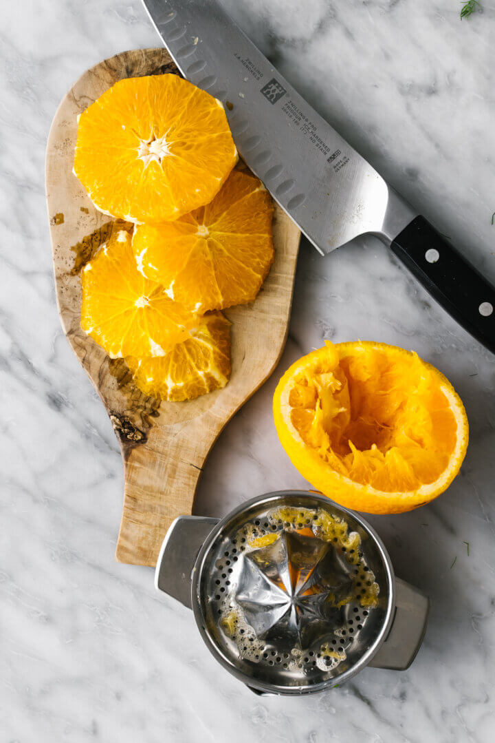 Sliced oranges with a knife for slow roasted salmon.