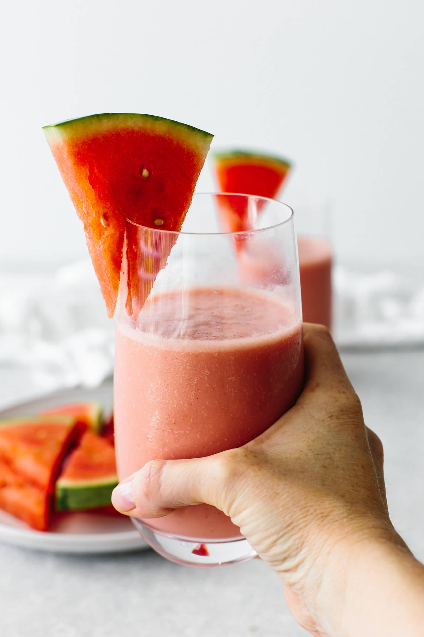 Holding a glass of watermelon smoothie