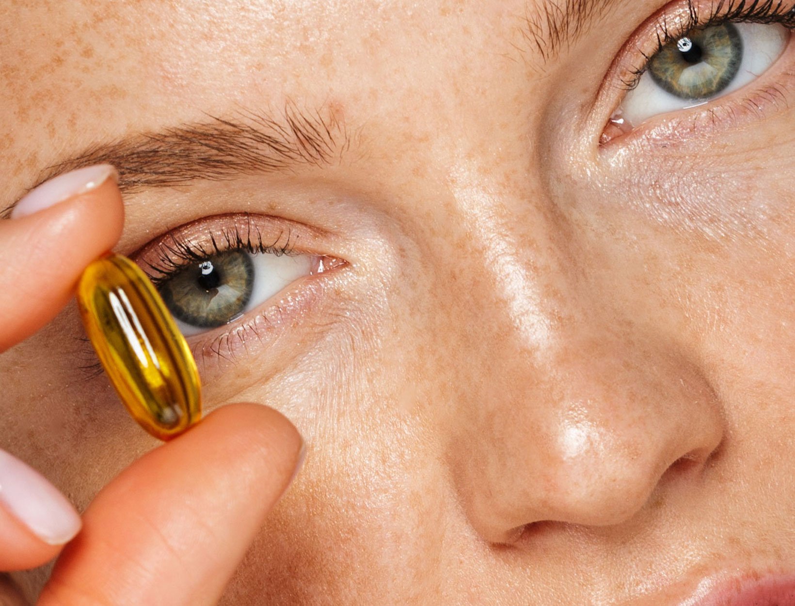 woman holding a supplement pill