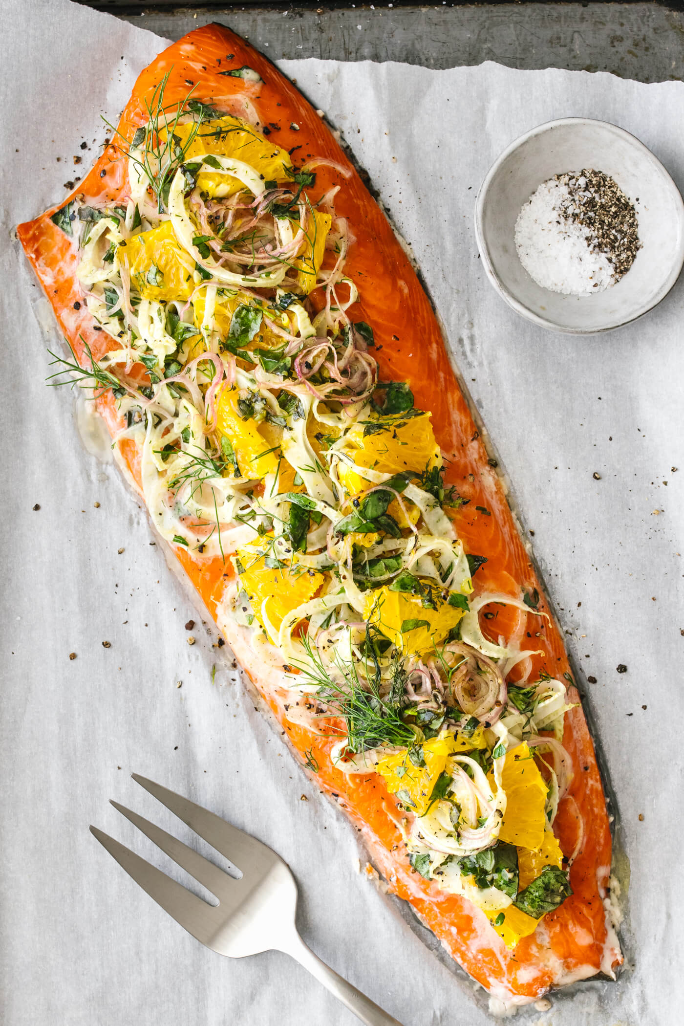 Slow roasted salmon with orange, fennel, and herbs on a sheet pan.