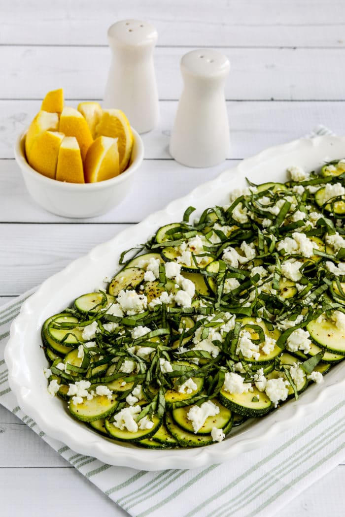Zucchini Carpaccio on serving plate with lemon slices in background