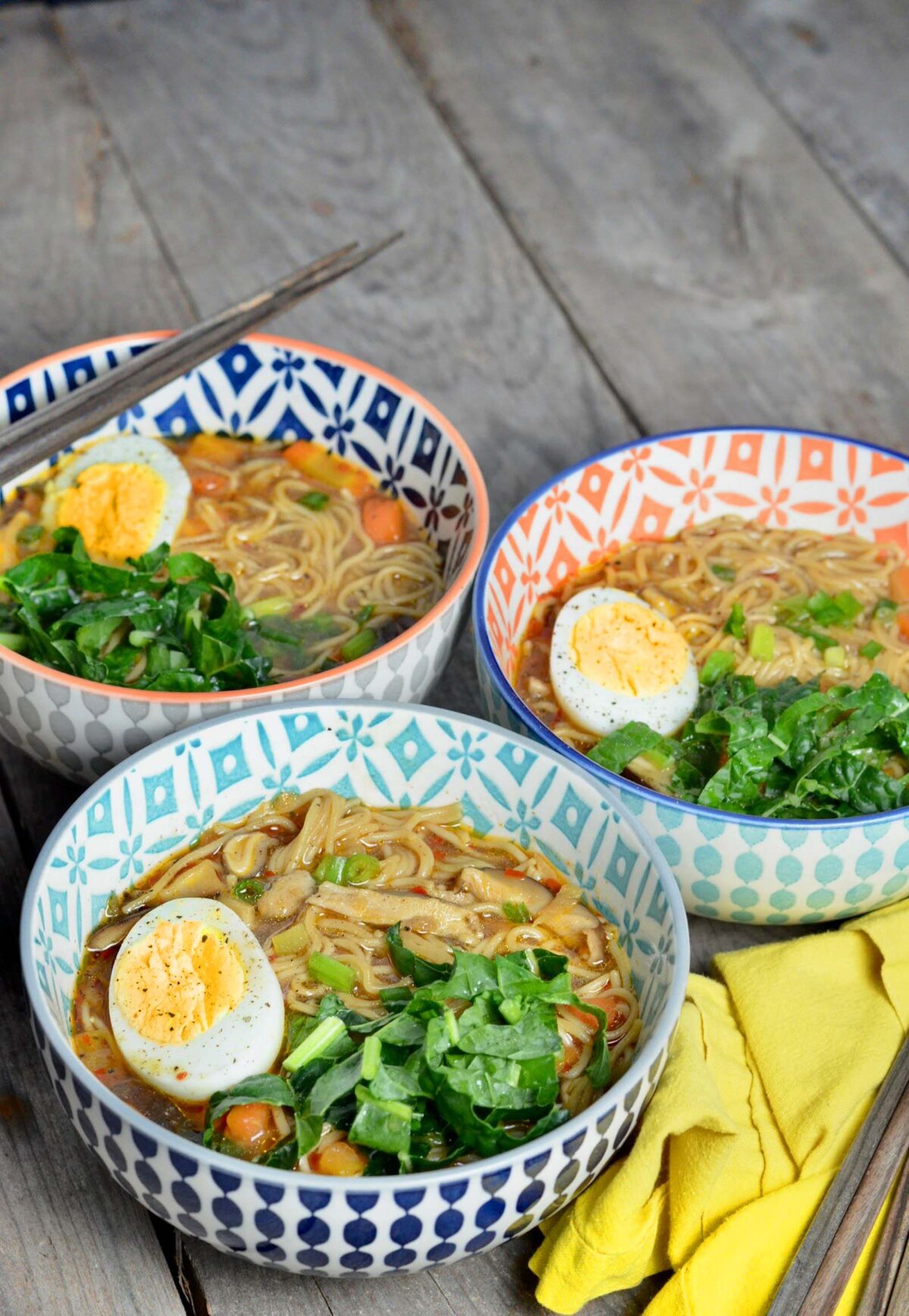 Three decorative bowls with homemade ramen on a table. 