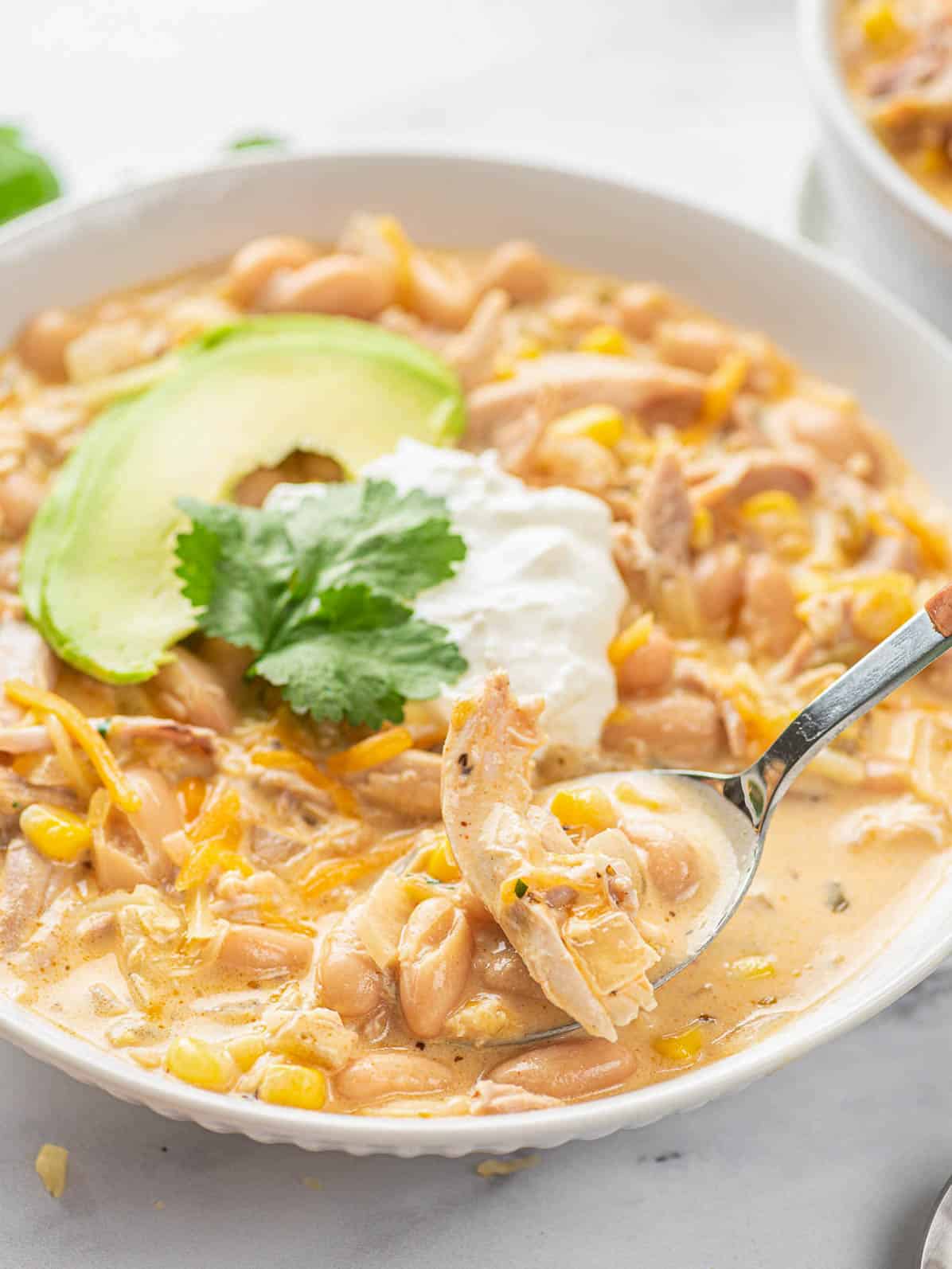 spoon scooping white chicken chili from plate