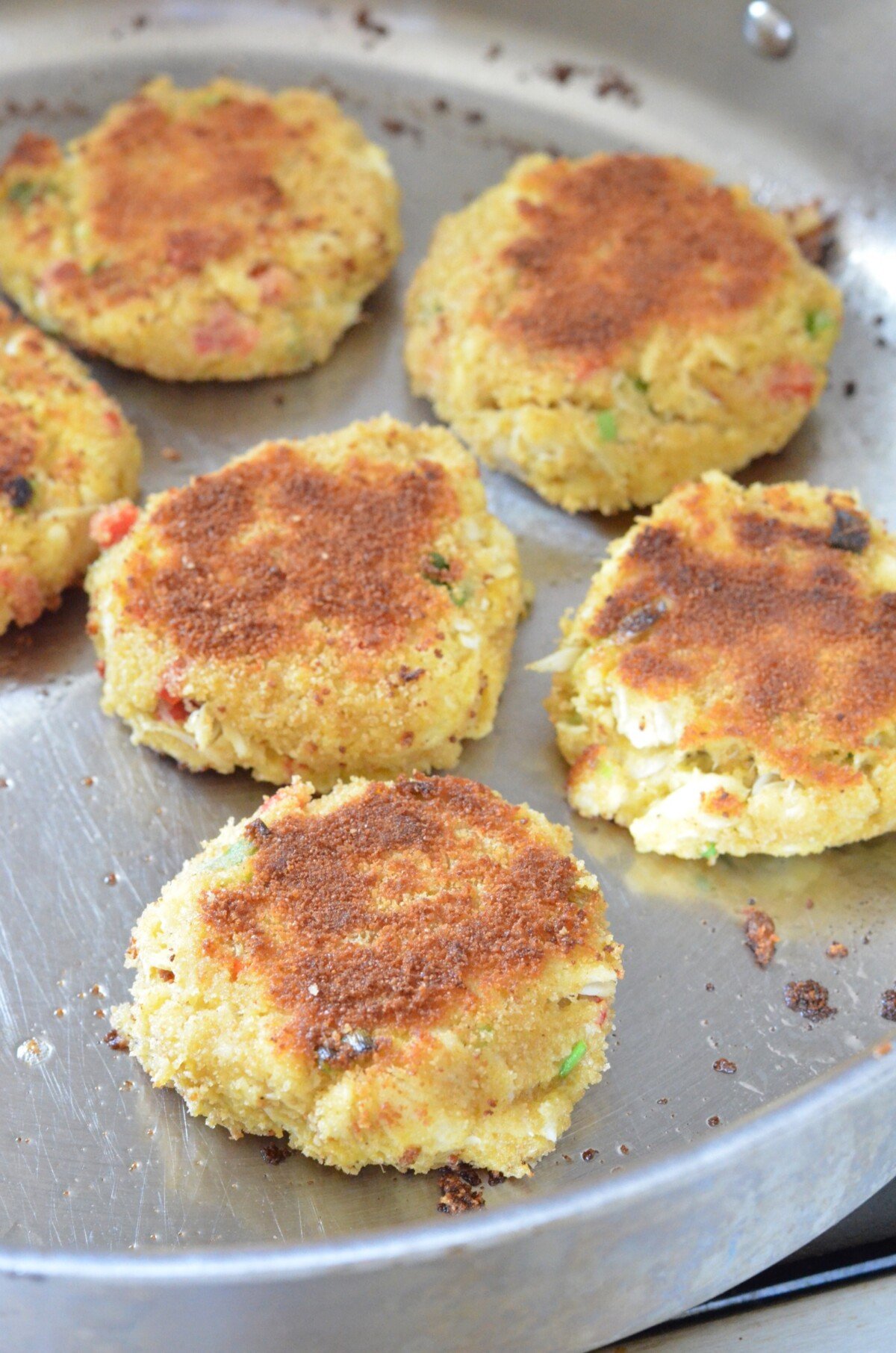 Crab Cakes being made in a frying pan. 