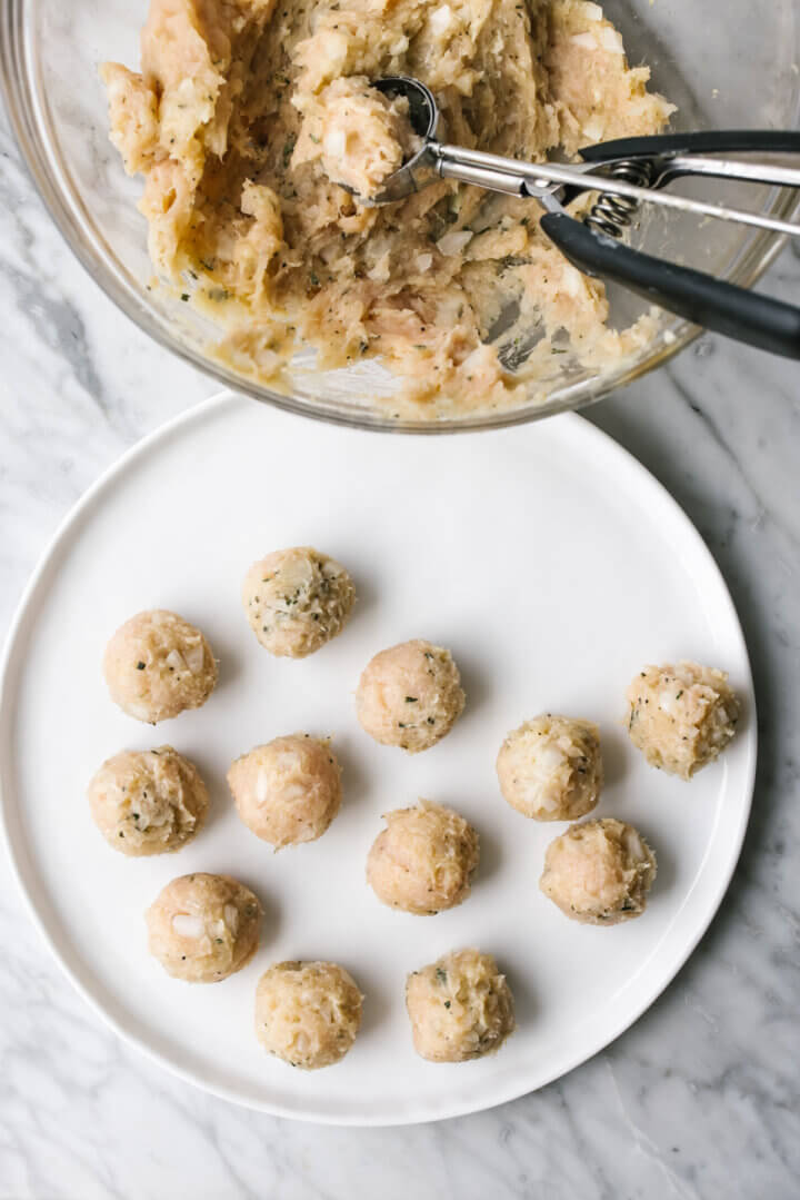 Forming turkey meatballs and placing on a white plate