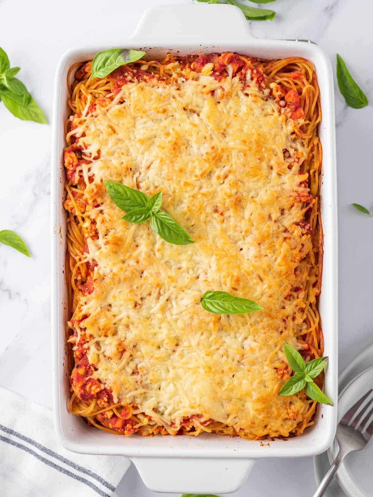 Easy Spaghetti Pasta Bake after cooking, topped with basil leaves.