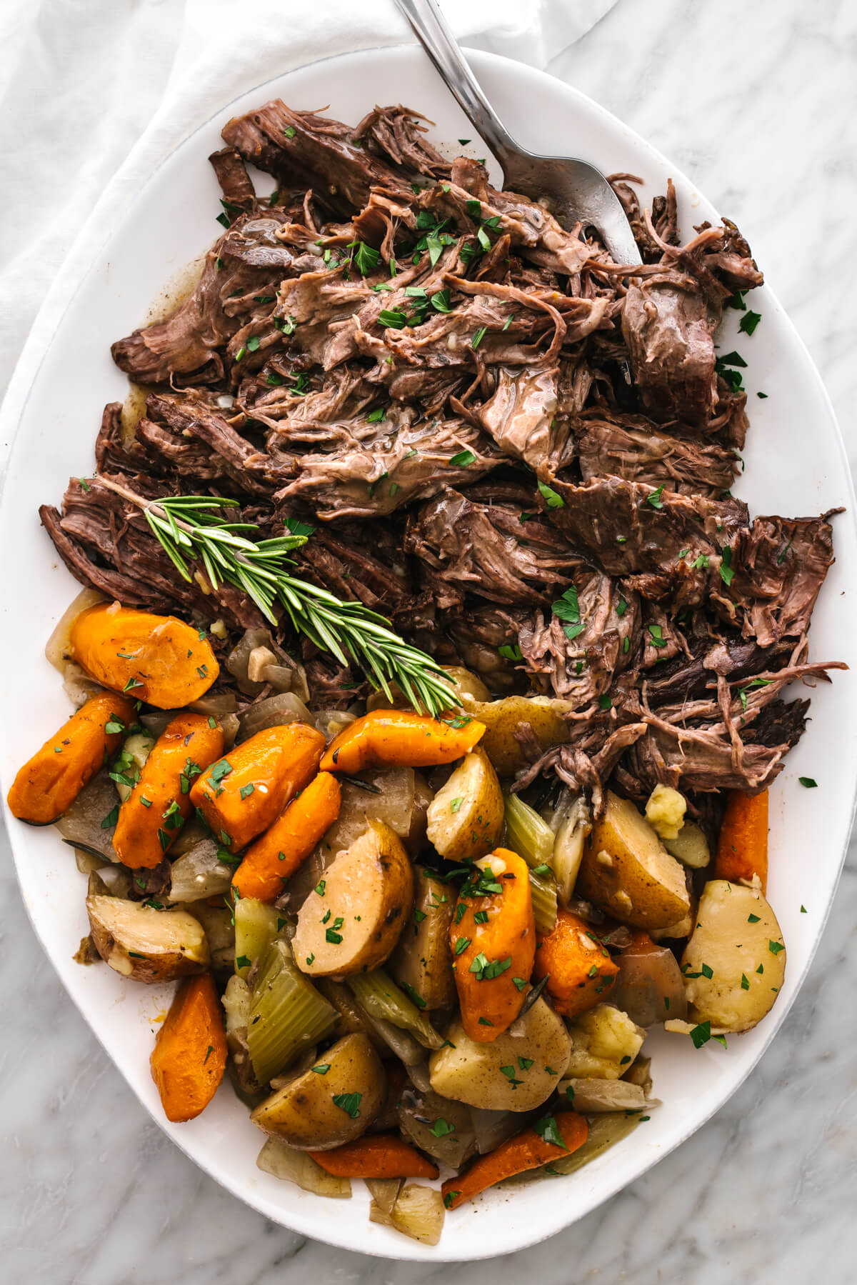 Slow cooker pot roast on a white serving plate