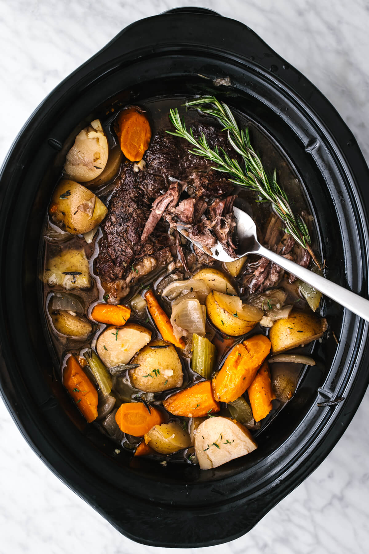 Slow cooker pot roast with a large serving spoon