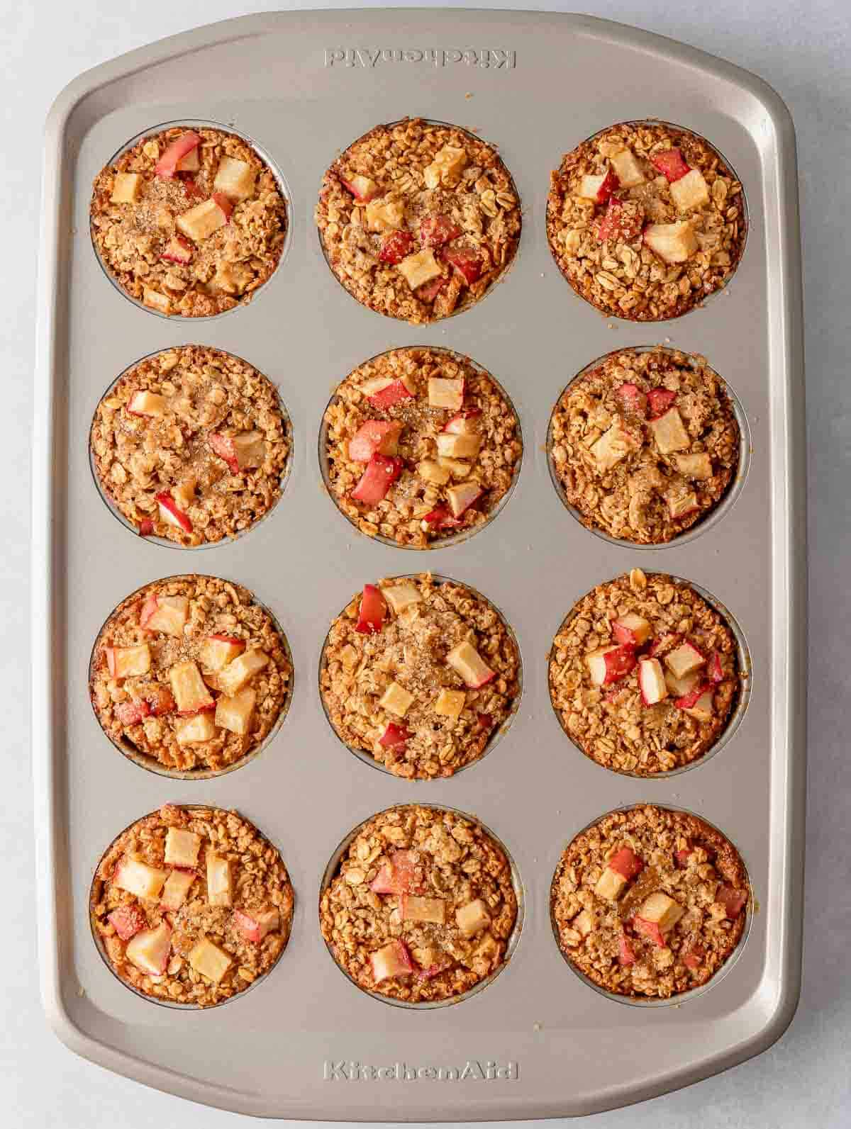 A muffin tin with cinnamon baked apple oats cups.