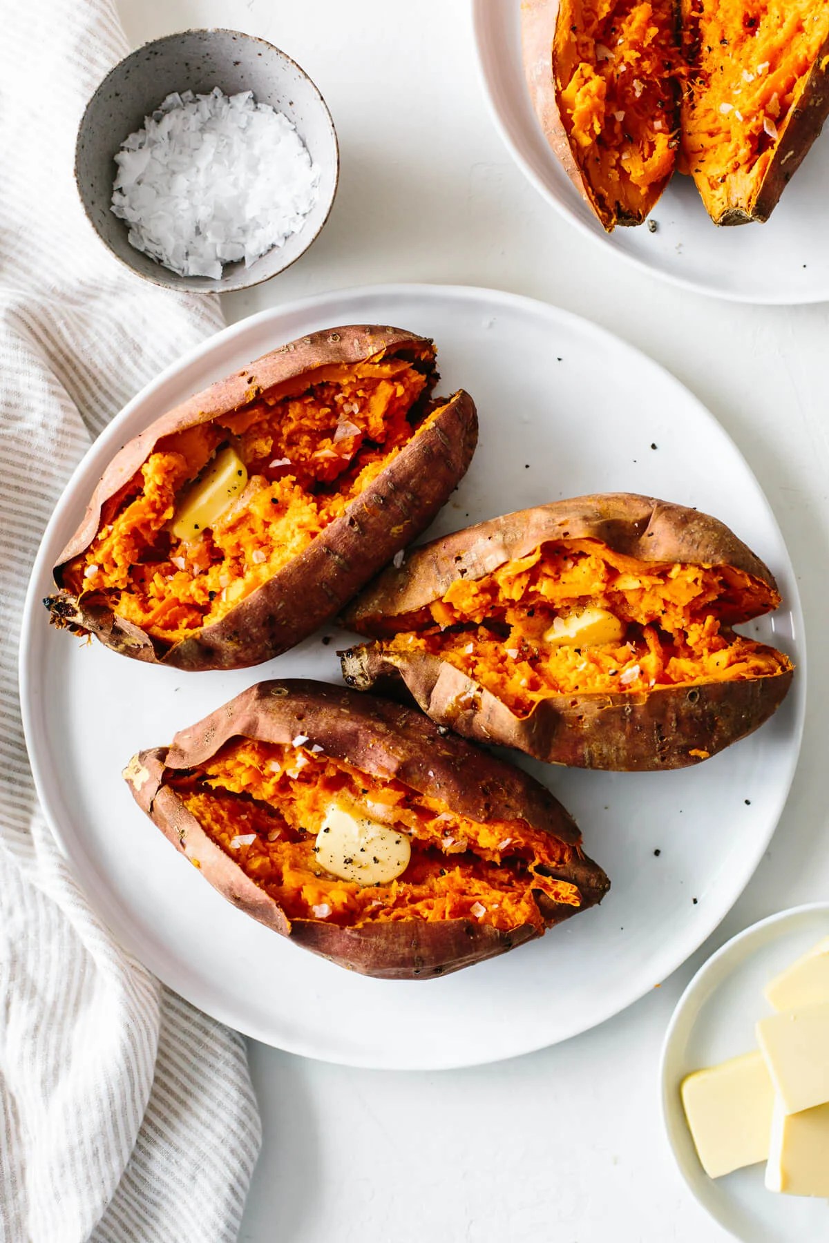 Baked sweet potatoes on a white plate.